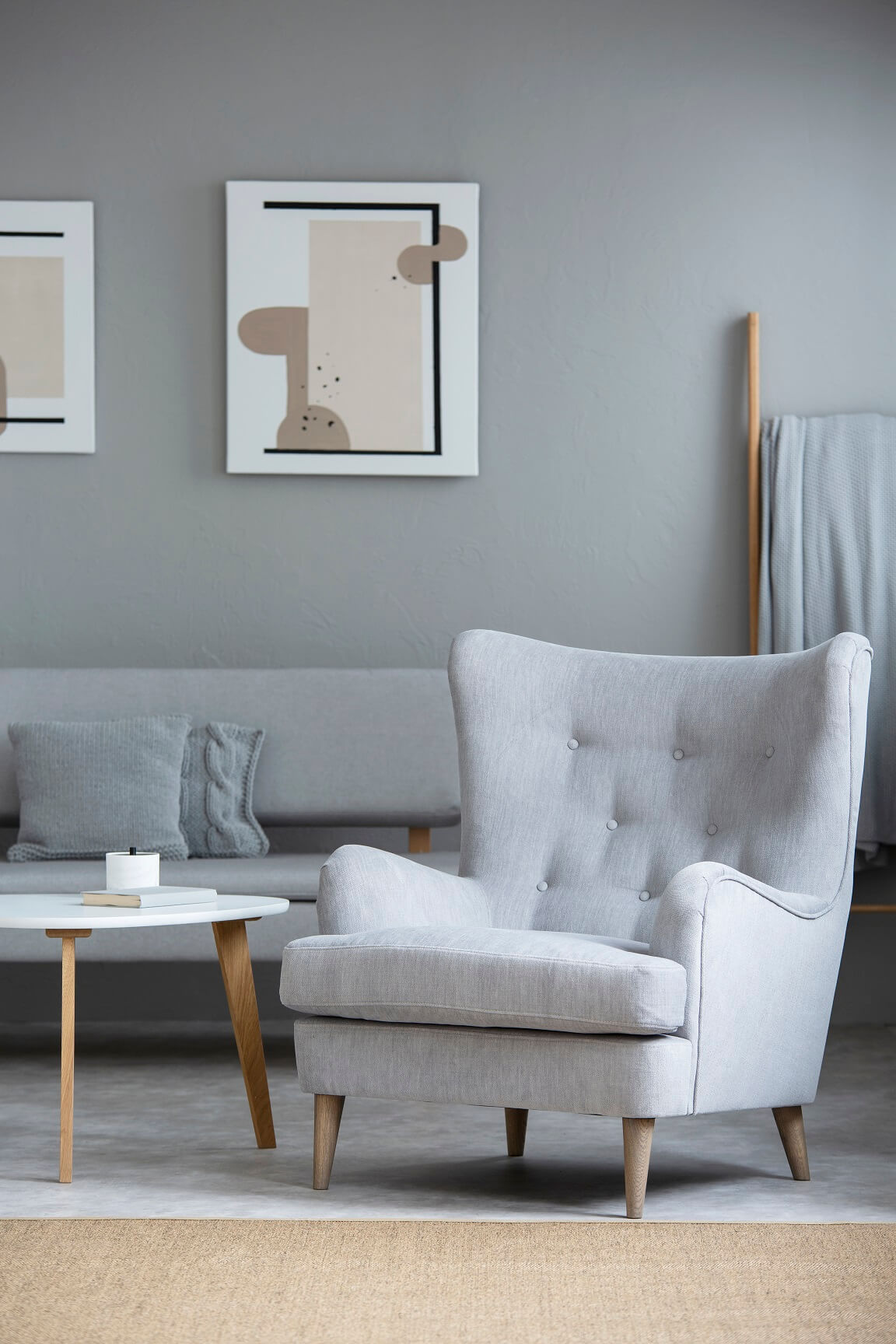 grey-armchair-next-to-table-in-living-room-interio-AQLM78J.jpg